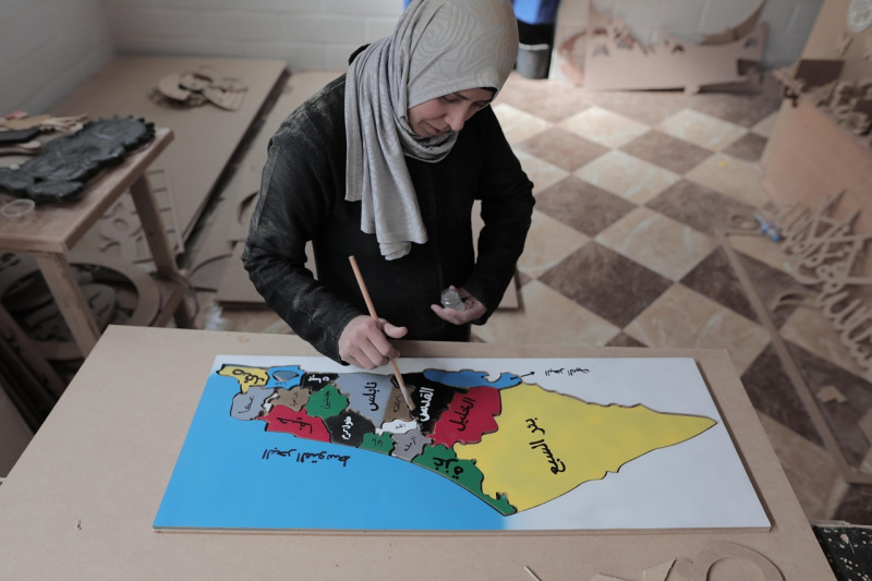 Mujer pinta un mapa que representa la diversidad de los territorios palestinos